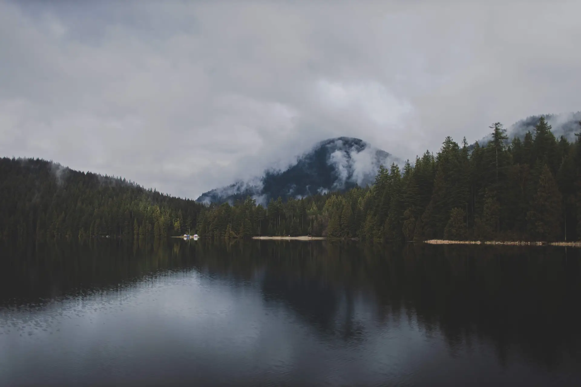 Atmospheric low clouds drifting above pristine wilderness lake